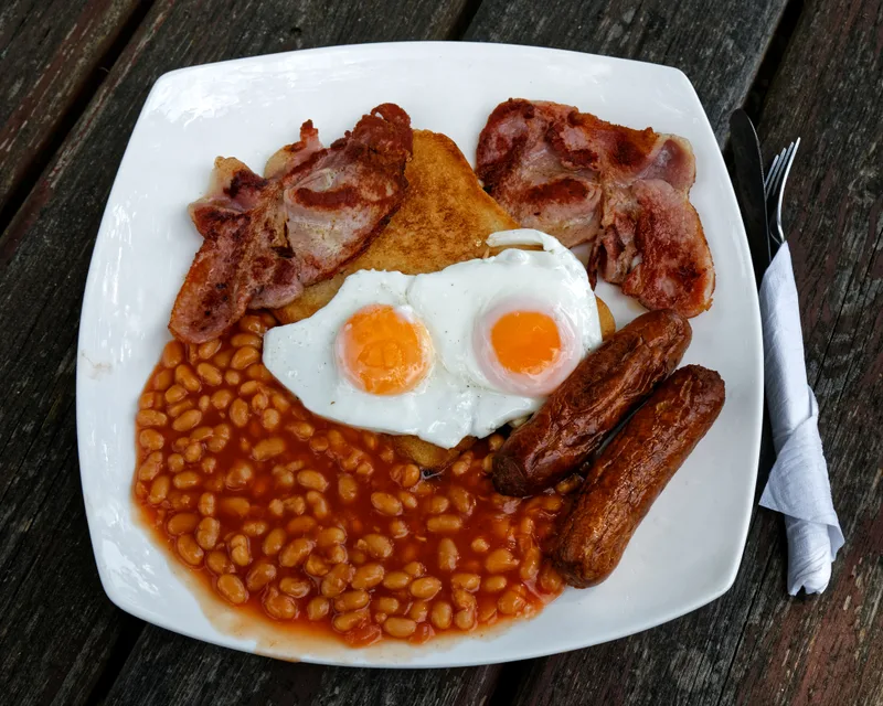 卵・ベーコン・ソーセージ・ビーンズ など が のっ た イギリス の 伝統 的 な 朝食