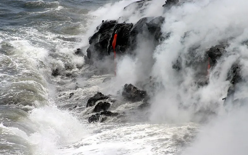 赤く流れ海に達する溶岩